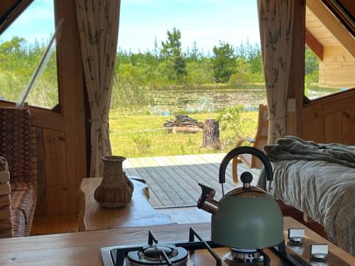a tea kettle on a stove in a room with a window at Plett Yellowwood Tiny House in Plettenbergbaai