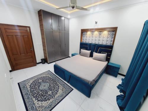 a small bedroom with a bed and a door at Kashees Lodges in Islamabad