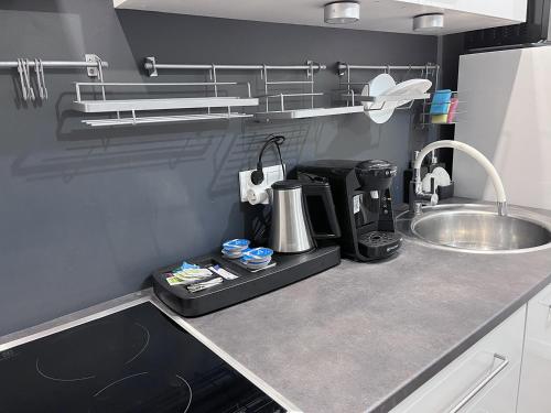 a kitchen counter with a coffee maker and a sink at Apartment near the Castle Malbork in Malbork