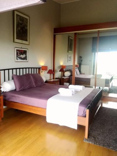 a bedroom with two beds and a large mirror at Superb Athens Airport Residence, Unique View in Spáta