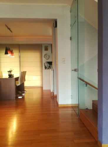 a living room with a glass door and a table at Superb Athens Airport Residence, Unique View in Spáta