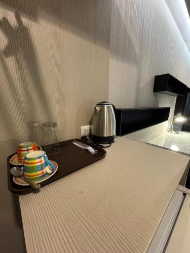 a kitchen with a tray with cups on a counter at Cha-am , Twin Bed Room , Naer Cha-am Beach South in Ban Bo Khaem