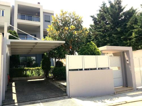 a white fence in front of a house at Superb Athens Airport Residence, Unique View in Spáta