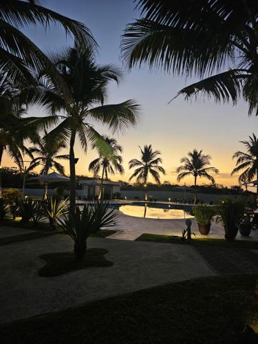 a person riding a bike under palm trees at sunset at Alojamiento Vacacional de Playa in Río Hato
