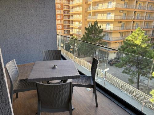 a balcony with a table and chairs and a building at MEGAN RESIDENCE - floor 3 in Shëngjin