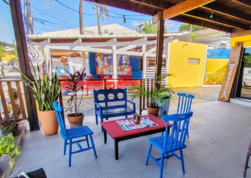 a patio with blue chairs and a table with a red table at Kabatukila Pousada in Natal