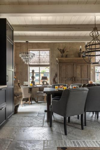 Bed and Breakfast Lokaal Wadway في Spanbroek: غرفة معيشة مع طاولة طعام وكراسي