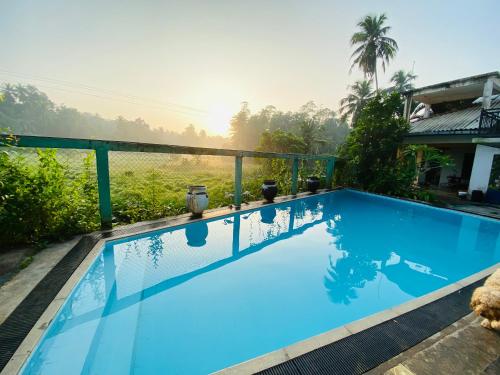a blue swimming pool in front of a house at Southern grace unawatuna in Unawatuna