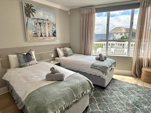 a bedroom with two beds and a large window at Riptide at no 14 in Sea Vista