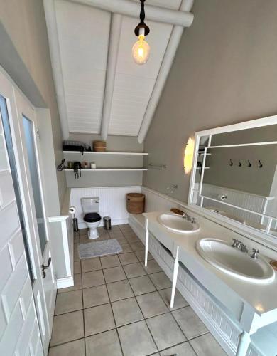 a bathroom with two sinks and a toilet at Riptide at no 14 in Sea Vista