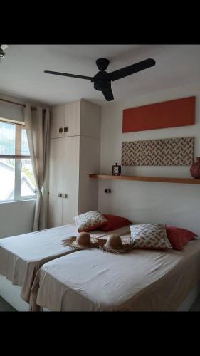 a bedroom with two beds and a ceiling fan at sea beach pool in Bain Boeuf
