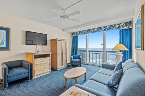 a living room with a couch and a tv at Yachtsman Oceanfront Resort in Myrtle Beach