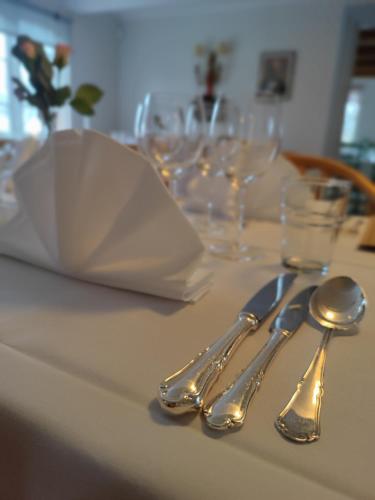 a table with silver utensils on a table with glasses at Kristianopel Gästgifveri in Karlskrona
