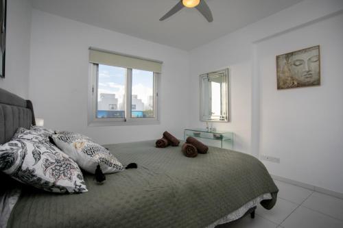 a bedroom with a bed with pillows and a ceiling fan at EDEN-Perfect Location, Sea View, Stylish Apartment in Paphos City