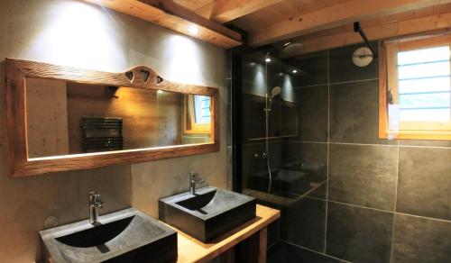 a bathroom with a sink and a mirror and a shower at Chalet savoyard écoresponsable, quasiment neuf 8 pers in Glières-Val-de-Borne