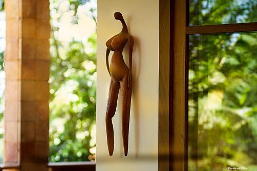 a wooden figurine of a person hanging on a window at Pousada Tímia in Morro de São Paulo