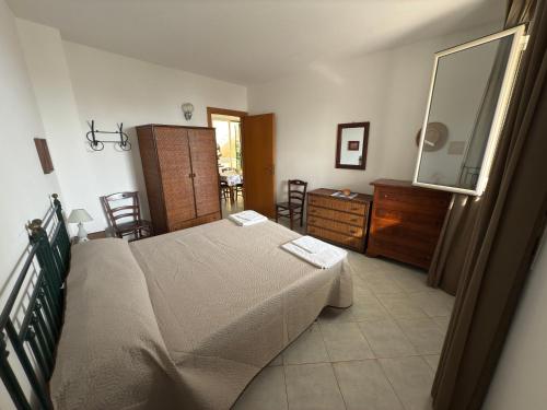 ein Schlafzimmer mit einem Bett, einer Kommode und einem Spiegel in der Unterkunft Casa BELLAVISTA tra MARE e TERME in Santa Cesarea Terme