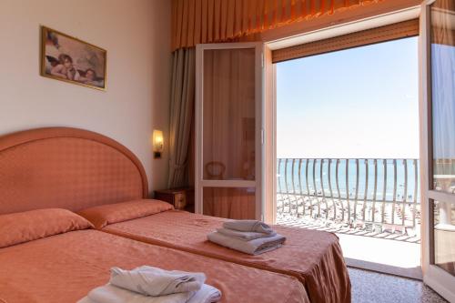 a hotel room with a bed with towels on it at Hotel Negresco in Milano Marittima
