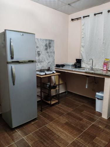 a kitchen with a refrigerator and a sink and a counter at La casa de Laly in Alto Boquete