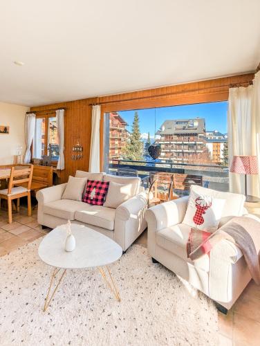 a living room with white furniture and a large window at Center of Nendaz ! Apartment 2 rooms with balcony in Nendaz