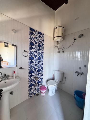a bathroom with a sink and a toilet and a mirror at Ikai Retreat in Mukteswar