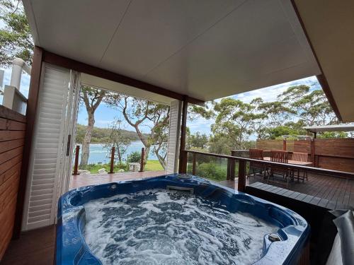 a hot tub on the deck of a house at Sussex Inlet Cillanti Retreat in Sussex inlet