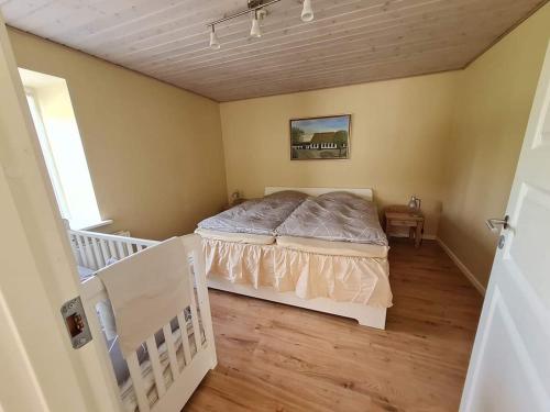 a bedroom with a bed in the corner of a room at Postgaarden Frøslev in Padborg