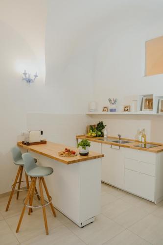 a kitchen with white cabinets and a wooden counter top at Casa Tua - Sea View Chianca in Vieste