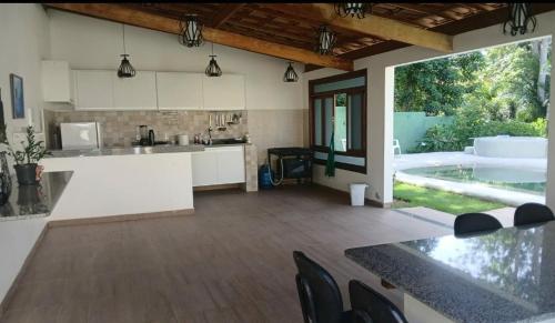 a kitchen with a counter top and a pool at Suíte Santo in Santa Cruz Cabrália