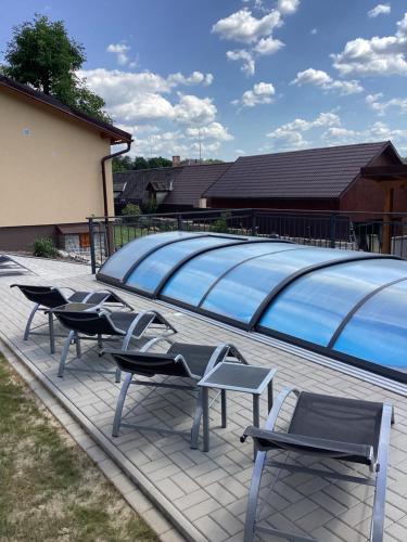 a group of chairs and a large swimming pool at Apartmány Ořechovka Wellness in Turnov