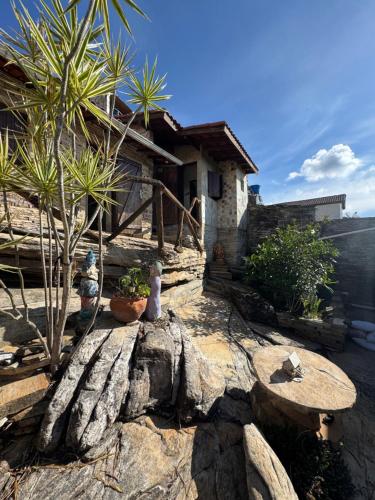 un patio con 2 panche, un tavolo e una casa di Pousada Morada do Soberano a São Thomé das Letras