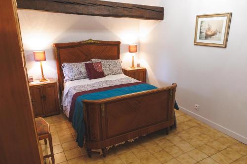 a bedroom with a wooden bed with two night stands at Gîtes du Château de Meux in Meux