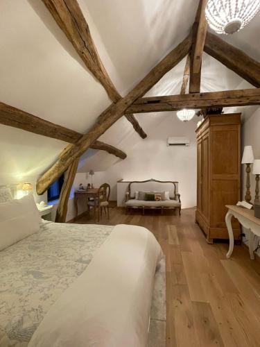 une chambre avec un grand lit et un bureau dans l'établissement Maison Charmille, à Féricy