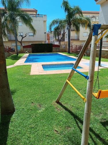 a playground with a slide next to a pool at Les Palmeres Centre in Les Cases d'Alcanar