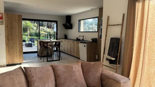 un salon avec un canapé et une cuisine avec une table dans l'établissement Maison neuve climatisée, à 2 pas du centre de Bédoin, La Villa Thélo, à Bédoin