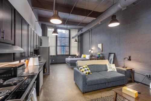 a large living room with a couch and a bed at Heart of Strip District - King Bd - Rooftop and Gym in Pittsburgh