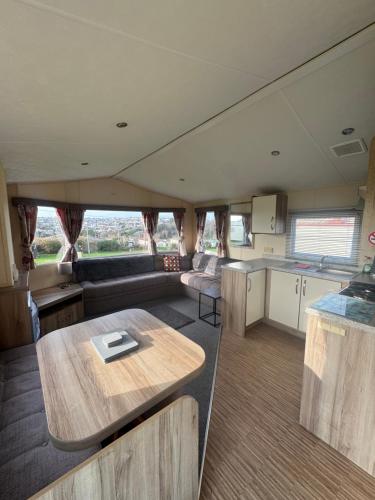 a kitchen and a living room with a table in a rv at Sea Shanty in Newquay