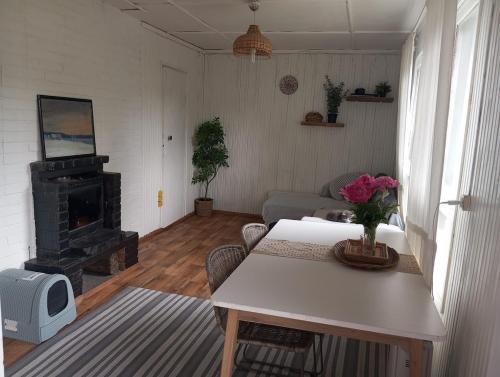 a living room with a table and a fireplace at Cozy cottage 30 min from Tallinn in Laitse