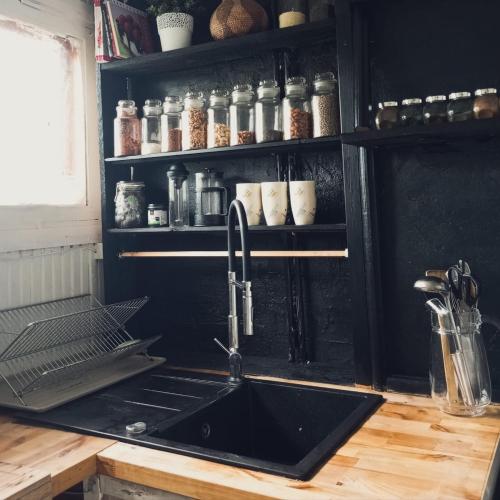 a kitchen with a sink and a counter with a shelf at Cozy cottage 30 min from Tallinn in Laitse