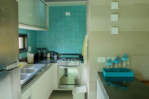 a kitchen with a sink and a stove at Bangalo Luxo Praia dos Carneiros Beach Resort in Praia dos Carneiros