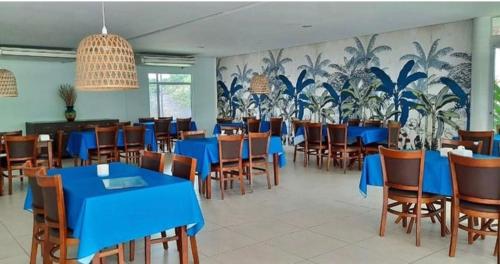 a dining room with blue tables and chairs at Bangalo Luxo Praia dos Carneiros Beach Resort in Praia dos Carneiros
