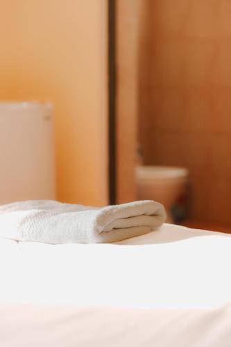 a towel on the edge of a bed in a bathroom at Haka Guesthouse in Golem
