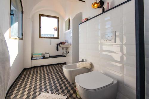 Un baño blanco con inodoro y lavabo. en Villa Villa Ida, en Lingueglietta