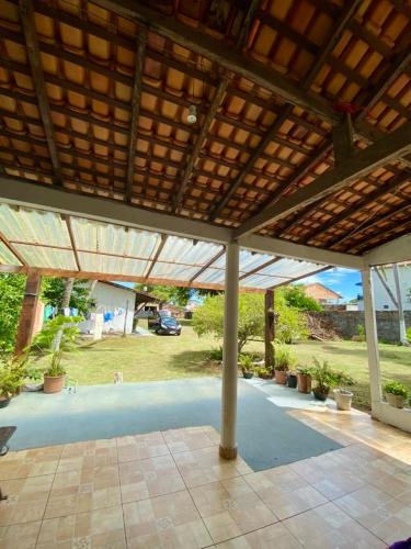 eine Terrasse mit einer hölzernen Pergola mit Topfpflanzen in der Unterkunft Casa Pena - Aluguel por temporada in Salvaterra