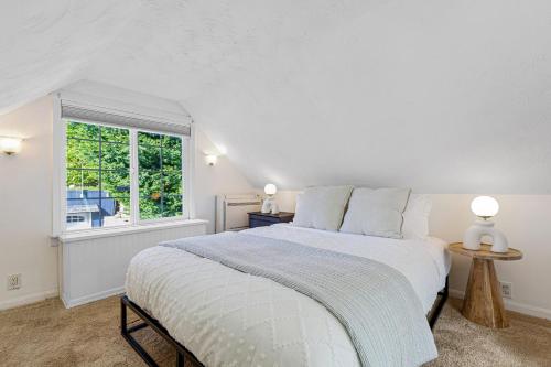 a white bedroom with a bed and a window at Lakefront cottage with AC in Federal Way
