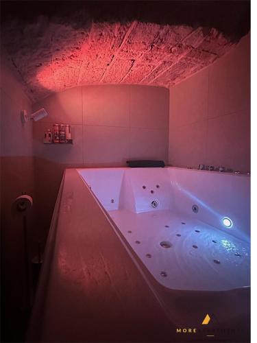 a large bath tub in a room with red lights at More Apartments Blue Arch suite in Bari