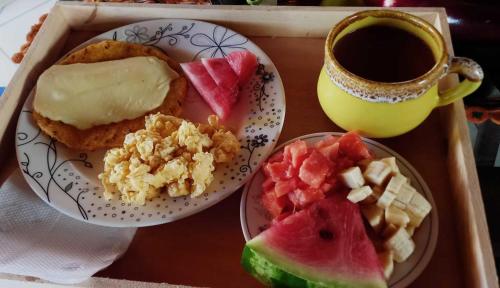 a tray with a plate of food and a cup of coffee at Boresta House -Santa Elena con vista al Bosque y terraza privada in Medellín