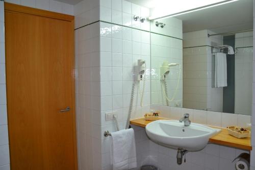 ein Bad mit einem Waschbecken und einem Spiegel in der Unterkunft Monestir de Les Avellanes in Os de Balaguer