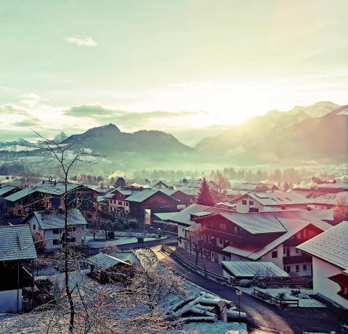 a village with snow covered roofs and buildings at Sunrise Pfronten - Budget in Pfronten