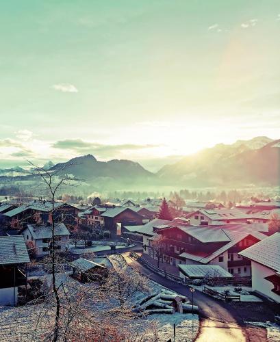 a small town with snow covered roofs and buildings at Sunrise Pfronten - Budget in Pfronten